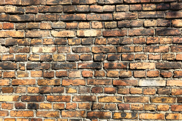 Old brick wall background with cracks, stains, and smoke damage. Textured background of a weathered brick wall. Aged surface with vintage, retro aesthetics suitable for industrial and historic themes.