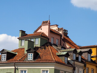 Colorful historic European townhouses with traditional architecture and red tile roofs in old city...
