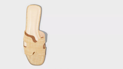 Stylish beige slide sandal designed for summer outings, showcasing a woven texture and open-toe style for comfort and breathability