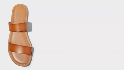Stylish brown leather sandal positioned on a white background showcasing its elegant design and subtle craftsmanship for summer wear
