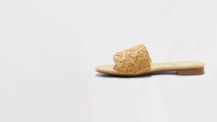 Stylish woven sandal highlighting summer trends in a minimalist setting with natural textures