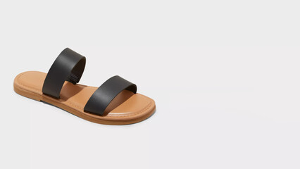 Stylish black and tan sandals on a neutral background showcasing modern footwear design