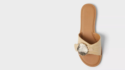 Stylish beige sandal with shell embellishment perfect for summer outings and beach wear in a modern setting