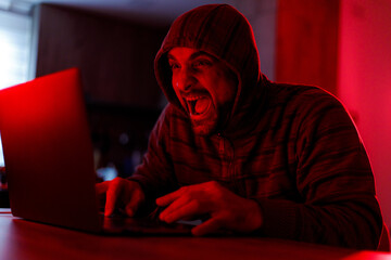 Excited individual engaged in online gaming at home