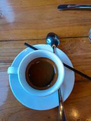A cup of espresso. Hot espresso in a white cup. Wooden table background.