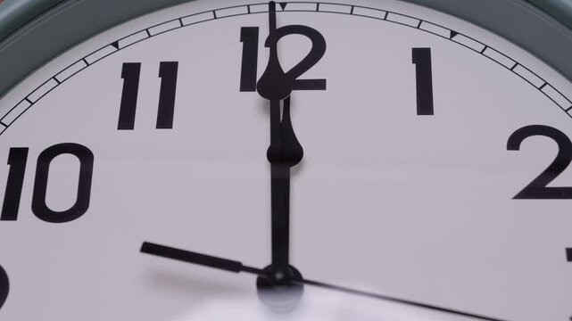 Detailed close-up of a wall clock showing the time at exactly 12:00 Symbolizing a new beginning countdown or deadline moment, themes of transition punctuality and time awareness.