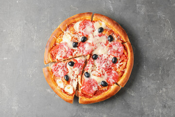 Tasty pizza with salami, cheese and olives on grey table, top view