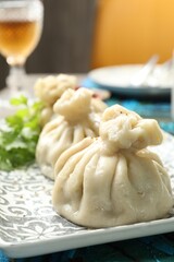 Delicious cooked khinkali served on table, closeup