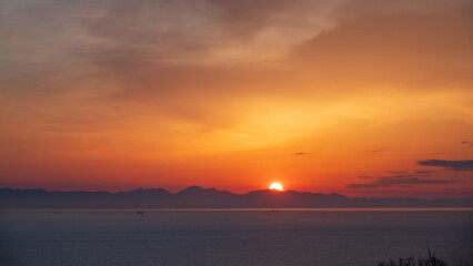 朝焼けの朝 対岸の山並みから昇る朝日