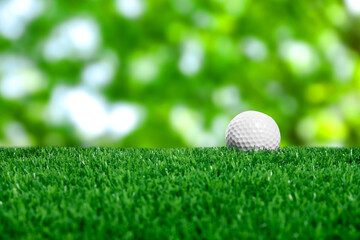 Golf ball on green grass outdoors, closeup