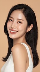 Beauty portrait of young Asian woman with tied black hair and glowing skin, smiling softly

