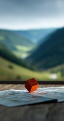 Orange Pixel Cube On Map With Mountain View