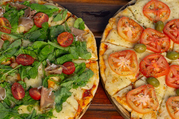 Dos Pizzas de restaurante vistas desde arriba con queso, tomates y RÚCULA 