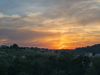 Dramatic sunset over suburbia, with warm colored houses