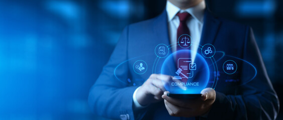 Businessman holding smartphone with compliance icons on screen - business and regulations concept