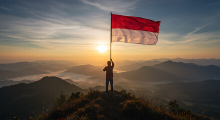 Person Raising Indonesian Flag at Sunrise on Mountaintop