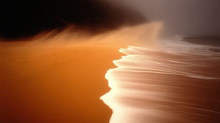 A water spray from the ocean misting over a sandy beach.