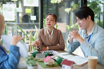 Eco-Friendly Solutions and Teamwork. A group discusses sustainable projects around a table.