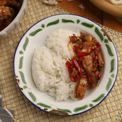 Stir fried salted fish with onion, garlic and chili on the table