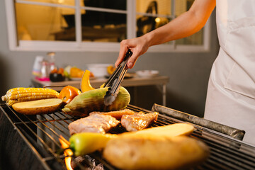A cheerful summer barbecue gathering with friends and family grilling meat outdoors, enjoying food, laughter, and togetherness in a sunny garden.