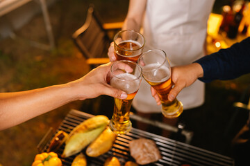 A cheerful summer barbecue gathering with friends and family grilling meat outdoors, enjoying food, laughter, and togetherness in a sunny garden.