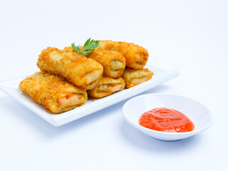 Golden crispy Indonesian risol mayo served with a side of spicy chili sauce on a white plate isolated on white background