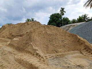 Expansive material area, dominated by large, meticulously organized stockpiles of raw materials...