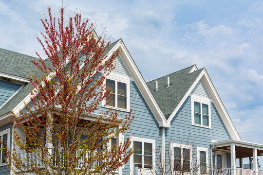 Upper facades of charming family homes with composite roofing and balconies in Brighton, Massachusetts, USA
