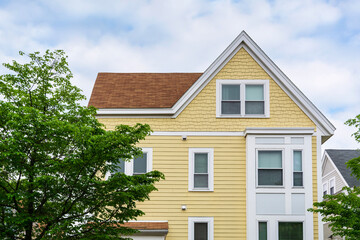 Elegant yellow family house with gabled roof and white trim accents in Brighton, Massachusetts, USA
