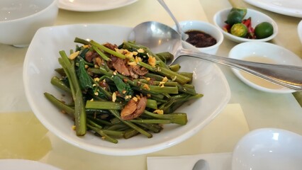 plate a Filipino vegetable dish Adobong kangkong, beans, pork belly