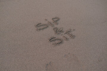 Sip and Sit – Handwritten Message on Volcanic Sand
