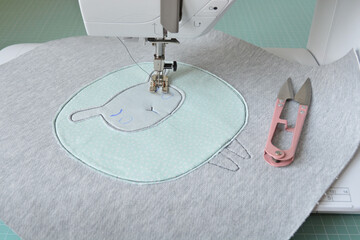 Cute sheep applique working process: sewing machine, thread snippers and fabric pieces