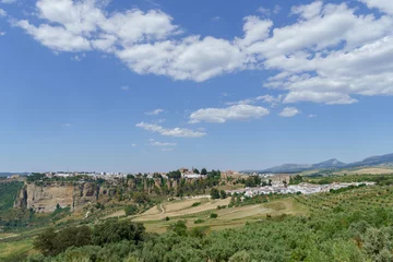 Scenic view of ronda,malaga,spain a white village perched on cliffs in andalusia, spain, under a blue sky with clouds