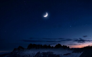 A night sky scene featuring a thin crescent moon and scattered stars over a dark, silhouetted mountain range, with hints of twilight on the horizon background.