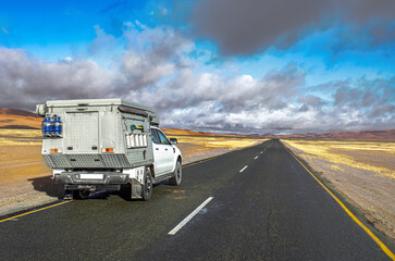 Safari car trip by road through sand dunes of Namib desert, extreme travel car adventure in Namibia, South Africa