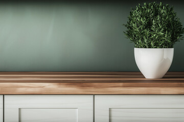 A vibrant green plant in a white pot sits on a sleek wooden counter in a modern interior.
