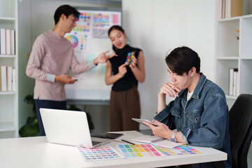 Creative Workflow and Inspiration. A graphic design team collaborating over color palettes and design direction.