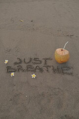 Just Breathe – Handwritten Message on Volcanic Sand with Coconut Drink