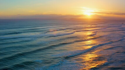 Fototapeta premium The ocean is calm and the sun is setting, creating a beautiful