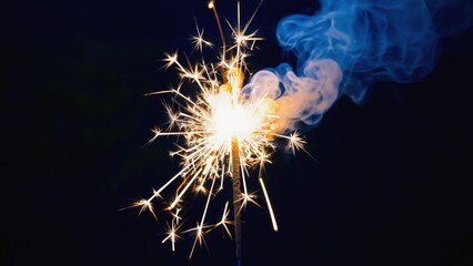 Sparkler is lit and the smoke is blue. Scene is celebratory and festive
