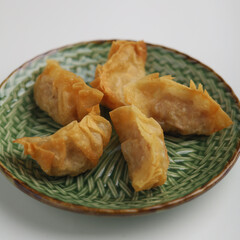 Gyoza or fried dumplings on a plate on white background