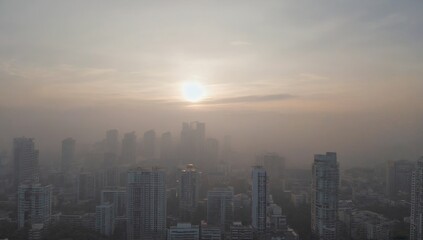 Fototapeta premium City skyline with a sun in the sky. The sun is setting and the sky is hazy