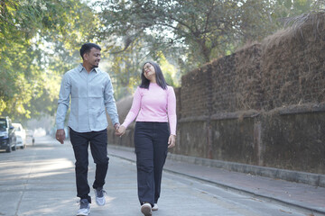 Obraz premium A joyful young couple sharing a loving moment on a peaceful street surrounded by greenery