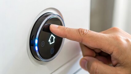 Naklejka premium Modern thermostat control with a finger pressing the button for home settings.
