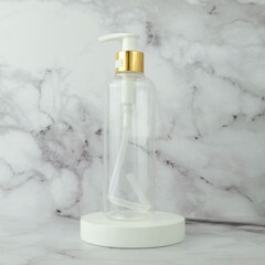 Clear pump bottle of body soap product on white podium display