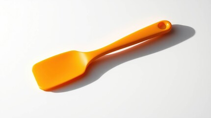 Bright orange silicone spatula, simple and clean design, lying diagonally on a white background