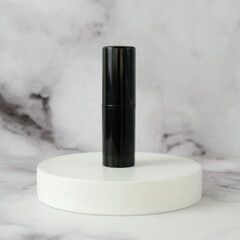 Black lip stick container on white podium