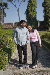 A joyful young couple sharing a loving moment on a peaceful street surrounded by greenery