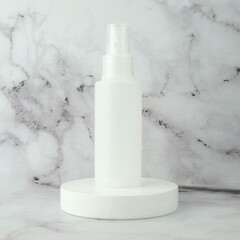 Spray bottle container on white podium display