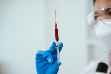 A medical technician analyzes blood samples in a laboratory, using advanced equipment for...